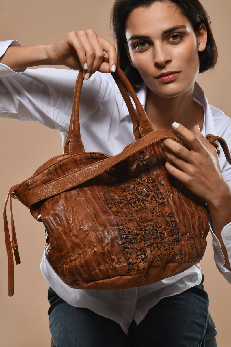 Cognac Nappa  leather handbag with embossed pattern on a white background.