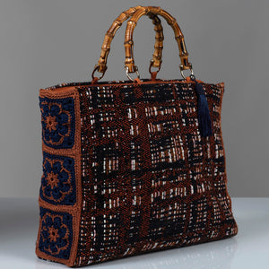 Cotton wool blend textured handbag with bamboo handles, crochet flower side panels and blue silk thread tassel.