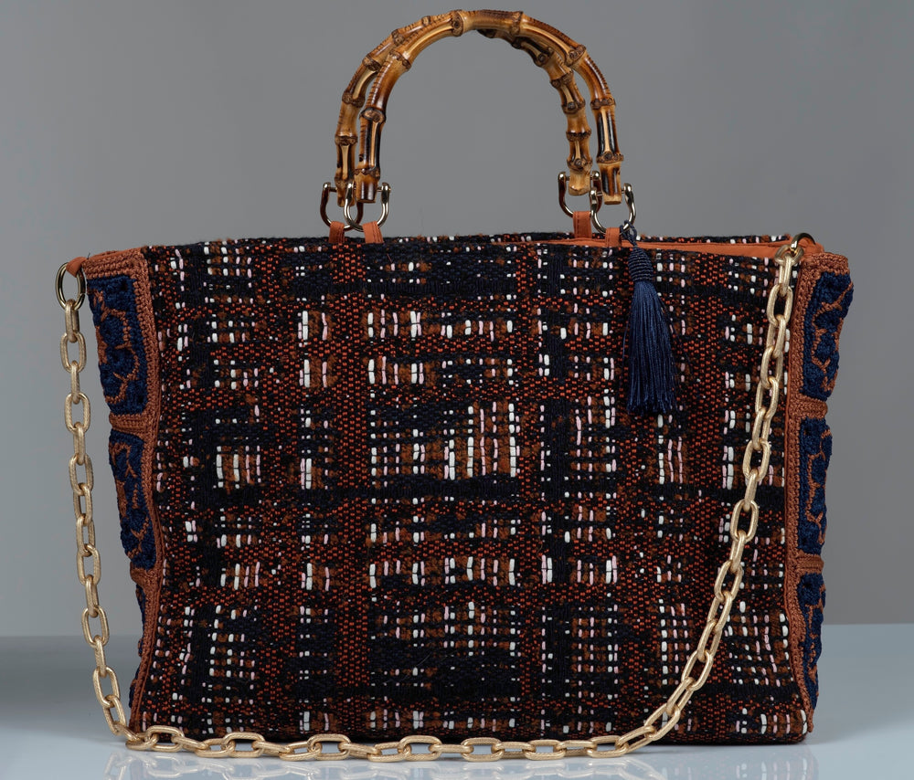 Cotton wool blend textured handbag featuring  gold chain, bamboo handles, and blue silk thread tassel. 