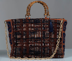 Cotton wool blend textured handbag featuring  gold chain, bamboo handles, and blue silk thread tassel. 