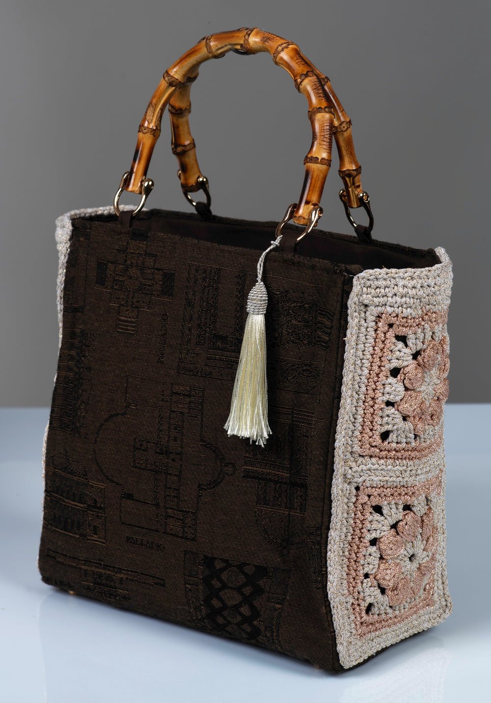 Chocolate brown monument-motif cotton handbag with bamboo handles and crochet side panels.