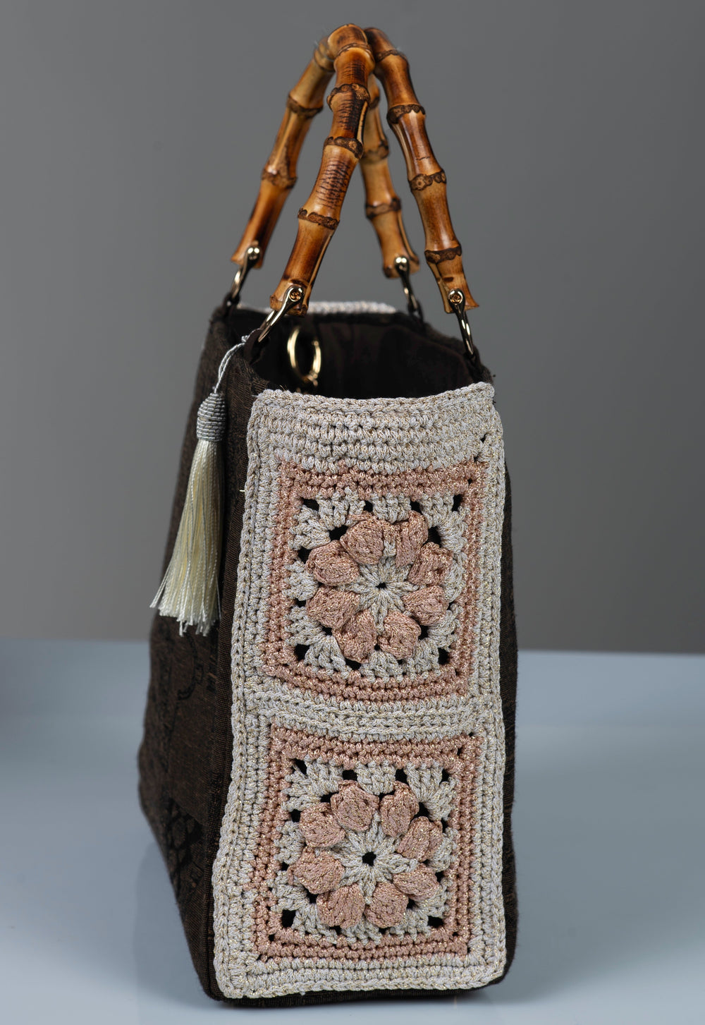 Handbag with crochet flowers side panel pattern and featuring bamboo handles and white silk thread tassel.  
