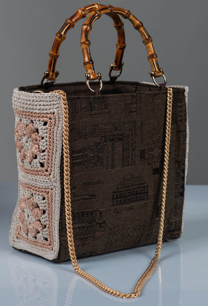 Brown textured handbag with bamboo handles, crochet flower side panels sand metal chain strap. 